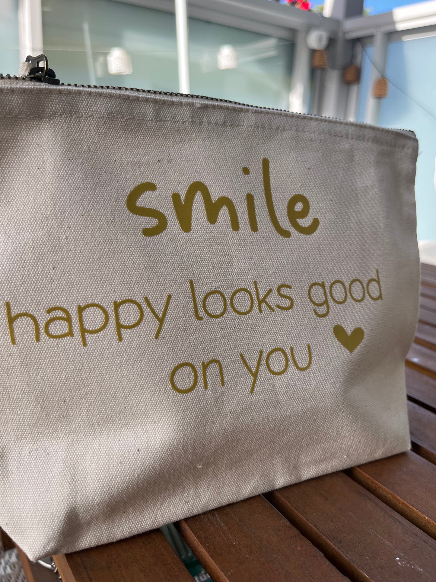 Helle Tasche mit Reißverschluss mit goldener Aufschrift SMILE